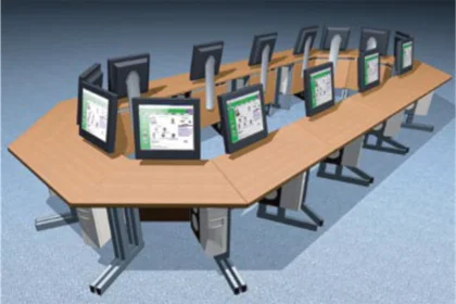 Conference table with dual-sided computer monitors and CPUs arranged for collaborative work.