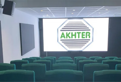 Small theater room with green seats facing a large screen displaying the word 'AKHTER'.