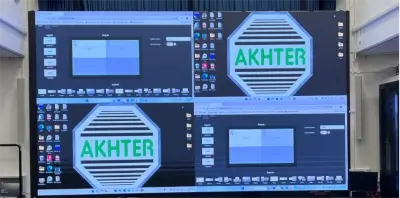 Small theater room with green seats facing a large screen displaying the word 'AKHTER'.