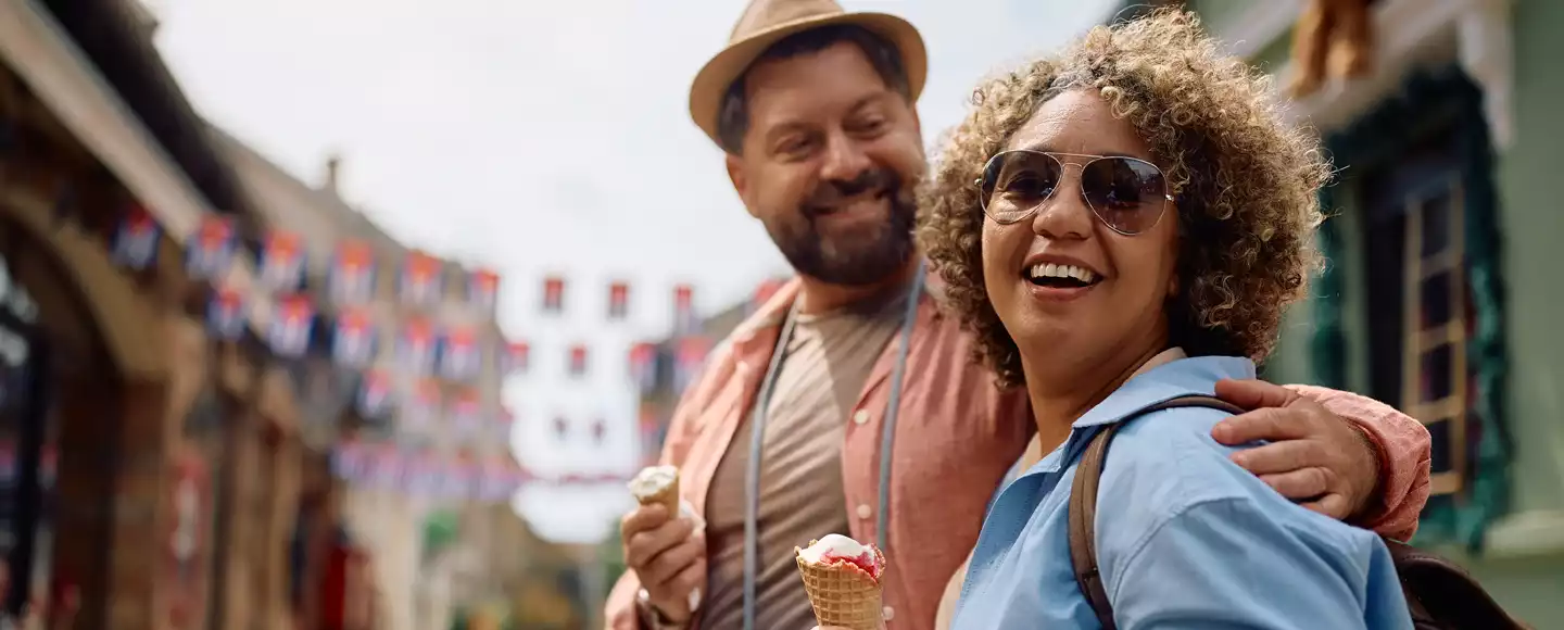 un homme et une femme sont en vacances et mangent une glace ensemble. ils ont choisi la meilleure destination ou partir en fonction du mois de l'année