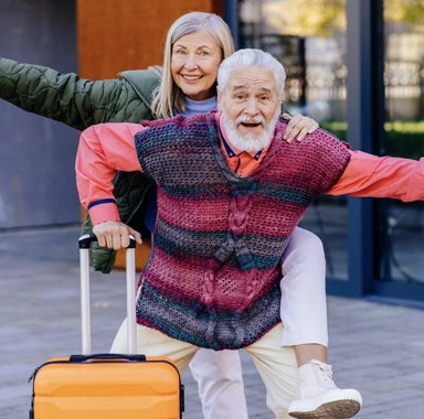 un couple heureux de partir en vacances danse avec sa valise, ils sont partis en vacances en janvier
