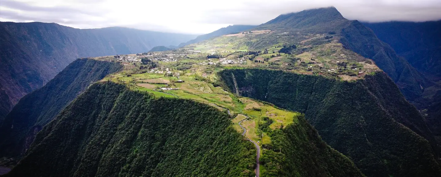 un large plateau au milieu des montagnes sur lequel se trouve un village. le lieu idéal pour en partir en vacances en mai