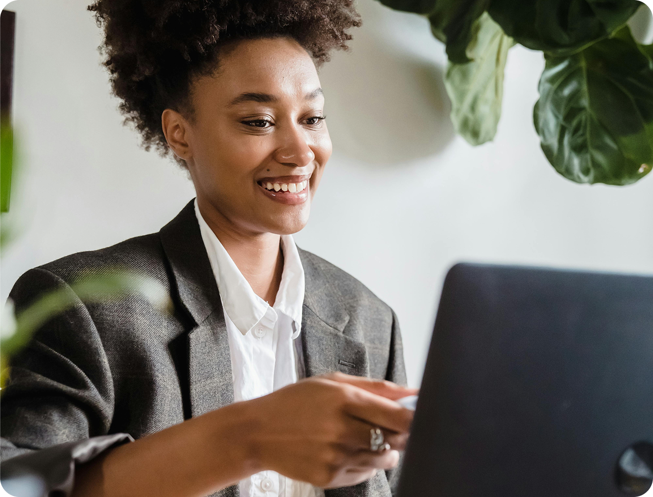 A professional smiling while working on a laptop