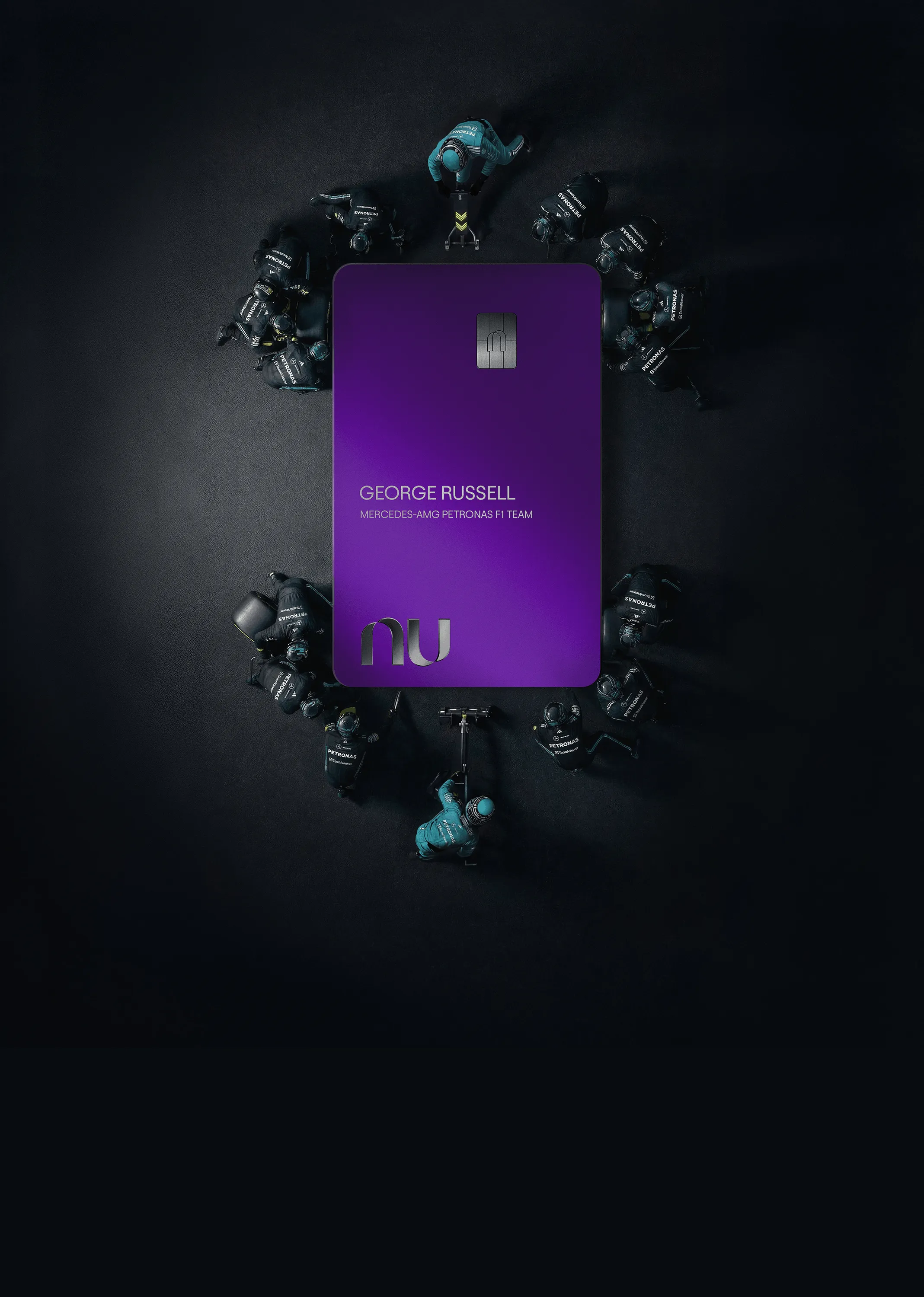 Overhead view of a purple credit card with George Russell’s name surrounded by a Formula 1 pit crew in black and teal uniforms.