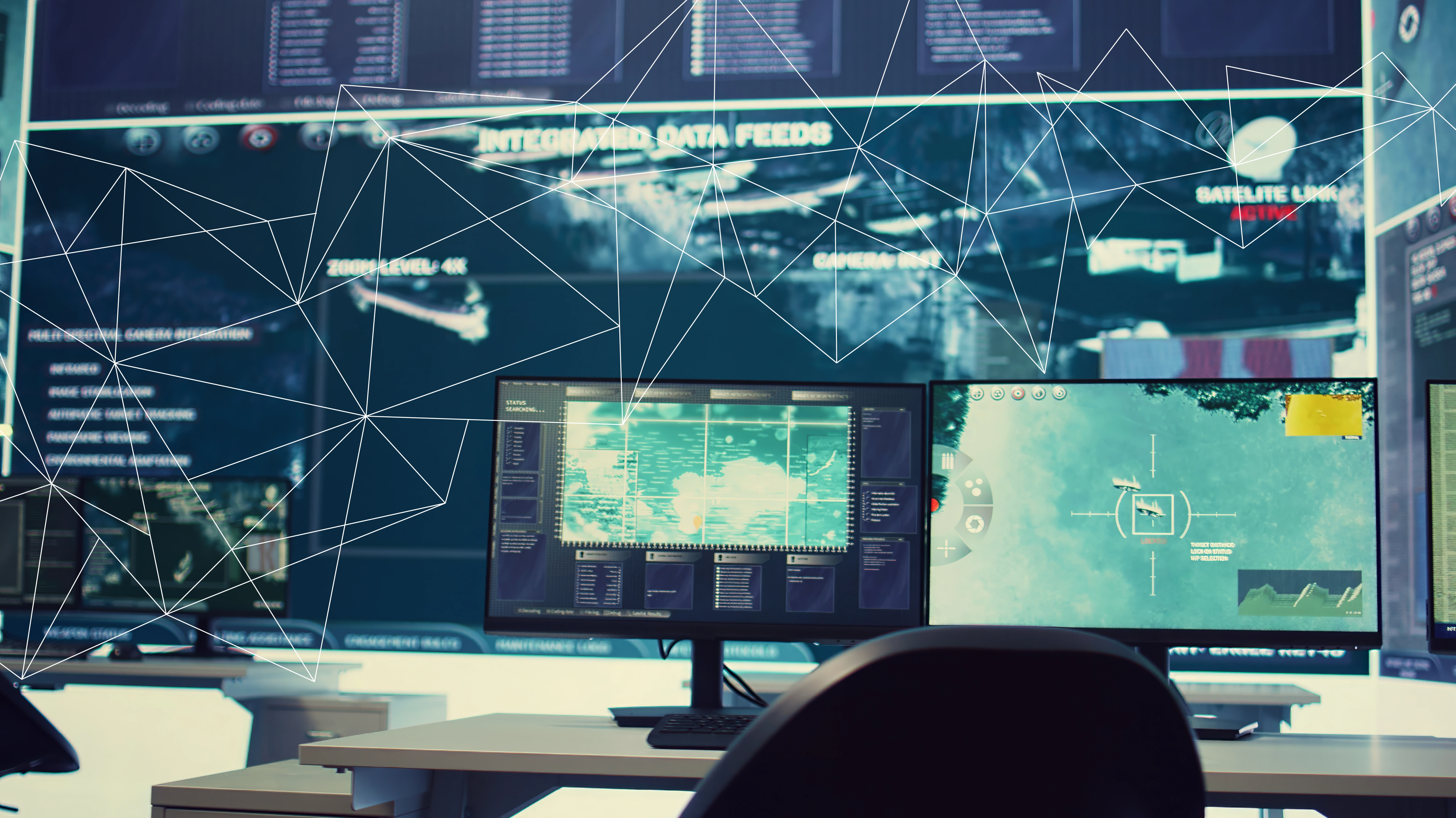 Computer monitors showing integrated data feeds and satellite links in a control room setting.