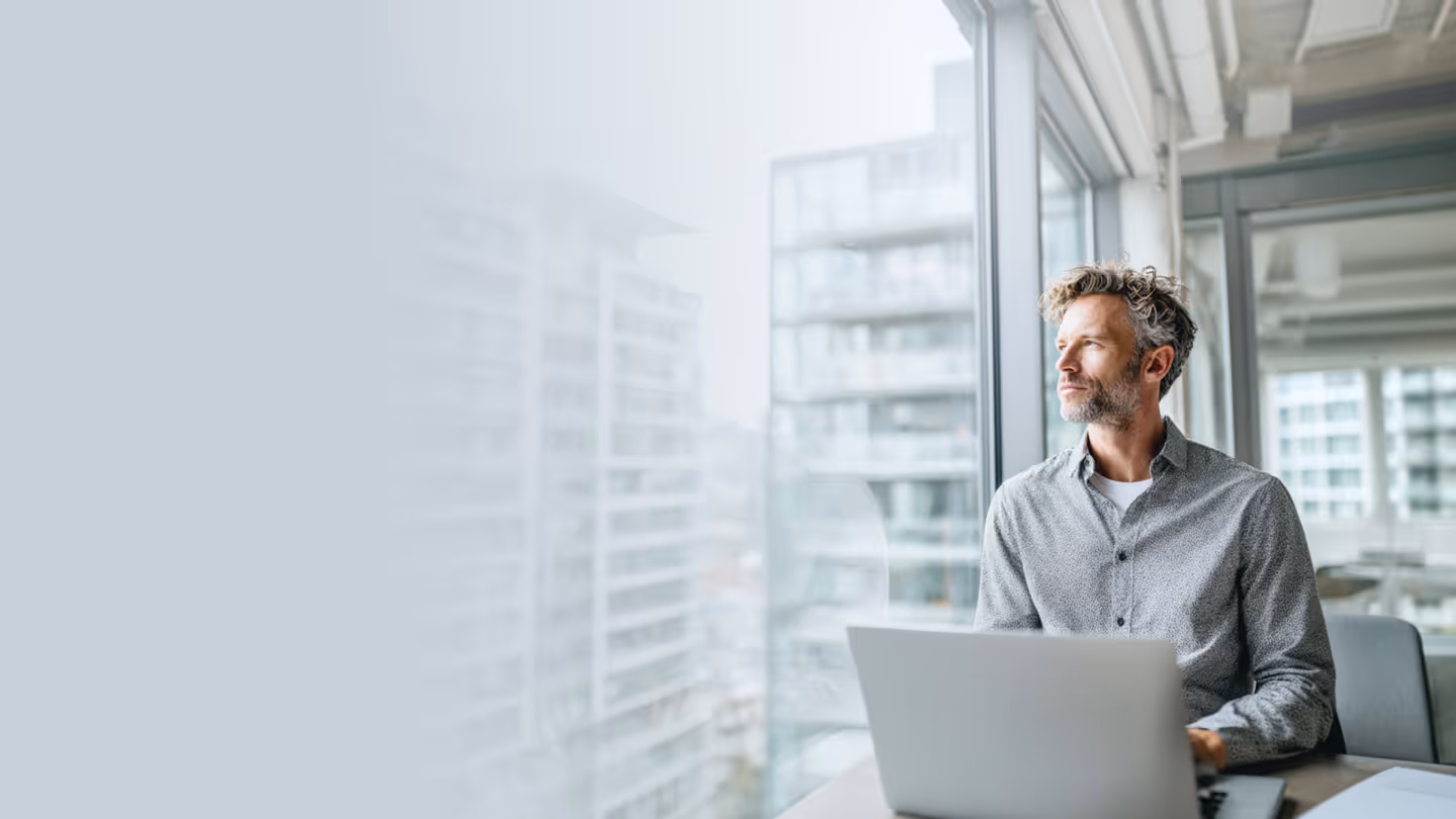 IT professional managing SASE and endpoint security on a laptop in a modern office environment.