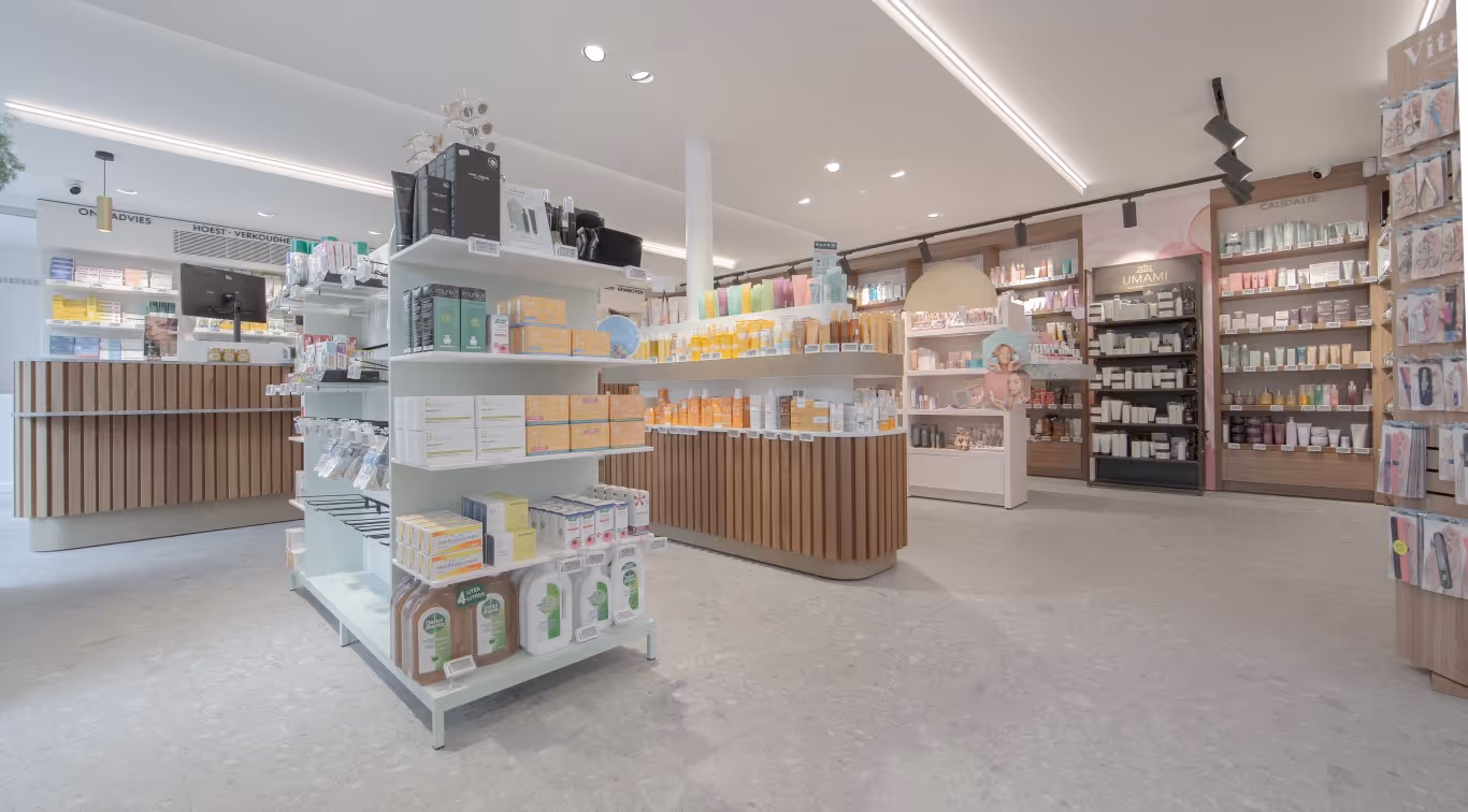 Verkoopruimte van apotheek Philips-Verstappen in Holsbeek met houten meubilair en vrijstaande schappen