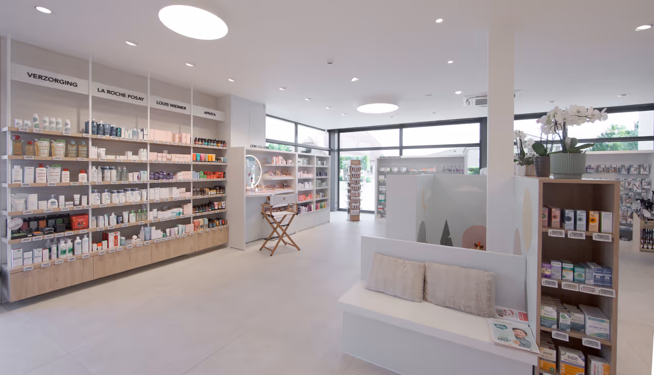 Winkelruimte met witte schappen in apotheek Deploige in Ham