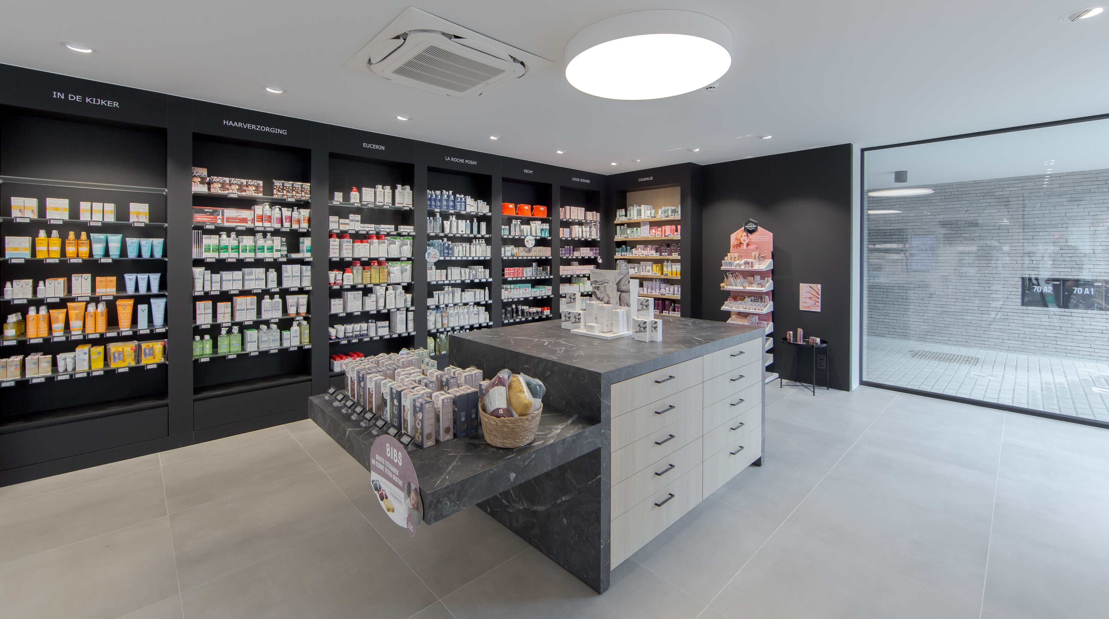 Huid- en haarverzorgingsproducten met centrale toonbank in apotheek Gooreind Pharma in Wuustwezel
