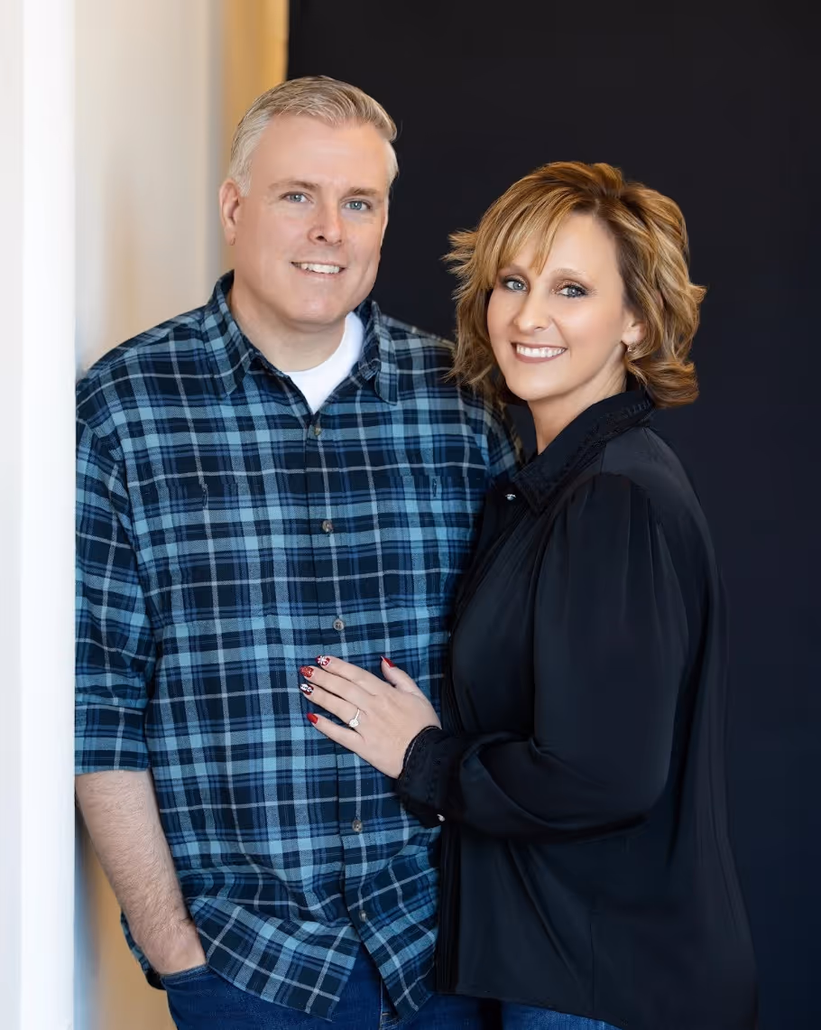Smiling middle-aged couple posing indoors.