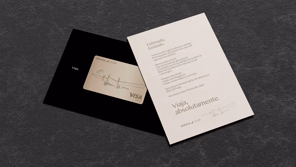 Tarjeta de crédito Iberia Club Visa en una funda negra junto a una carta personalizada dirigida a Gonzalo sobre la nueva forma de viajar con Zenit.