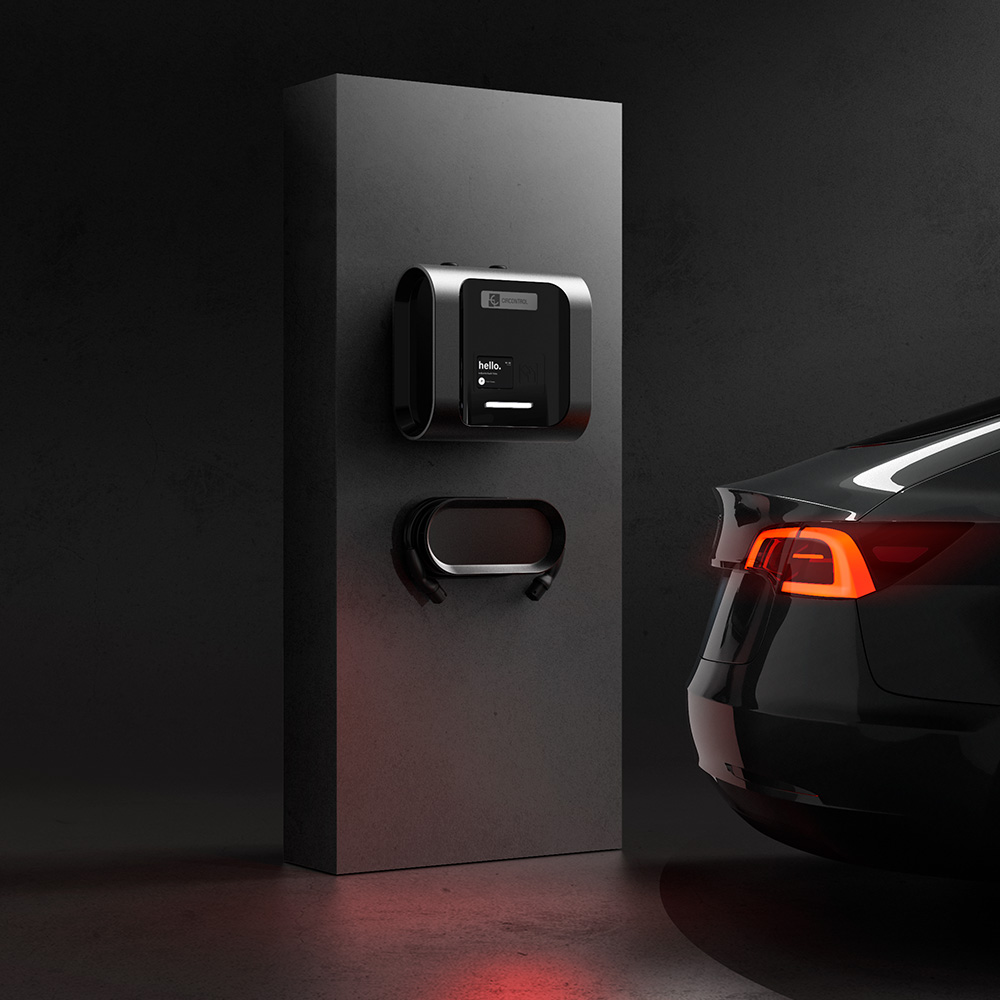 Cargador de vehículo eléctrico negro montado en soporte gris oscuro, con cable enrollado y parte trasera de un coche negro con luces traseras encendidas.