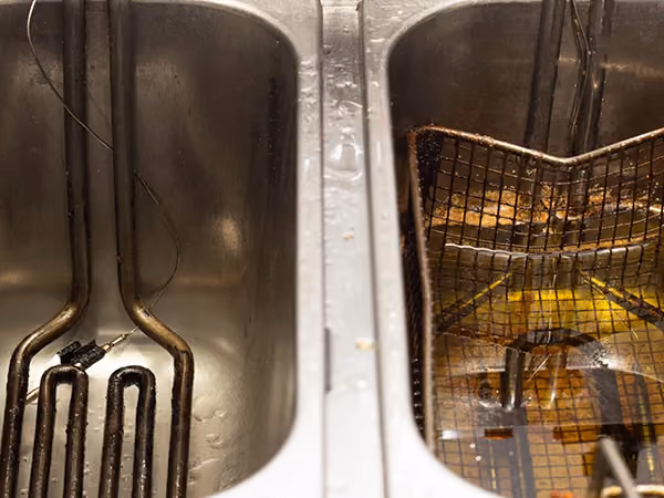 Two fryer vats. One empty, one with oil