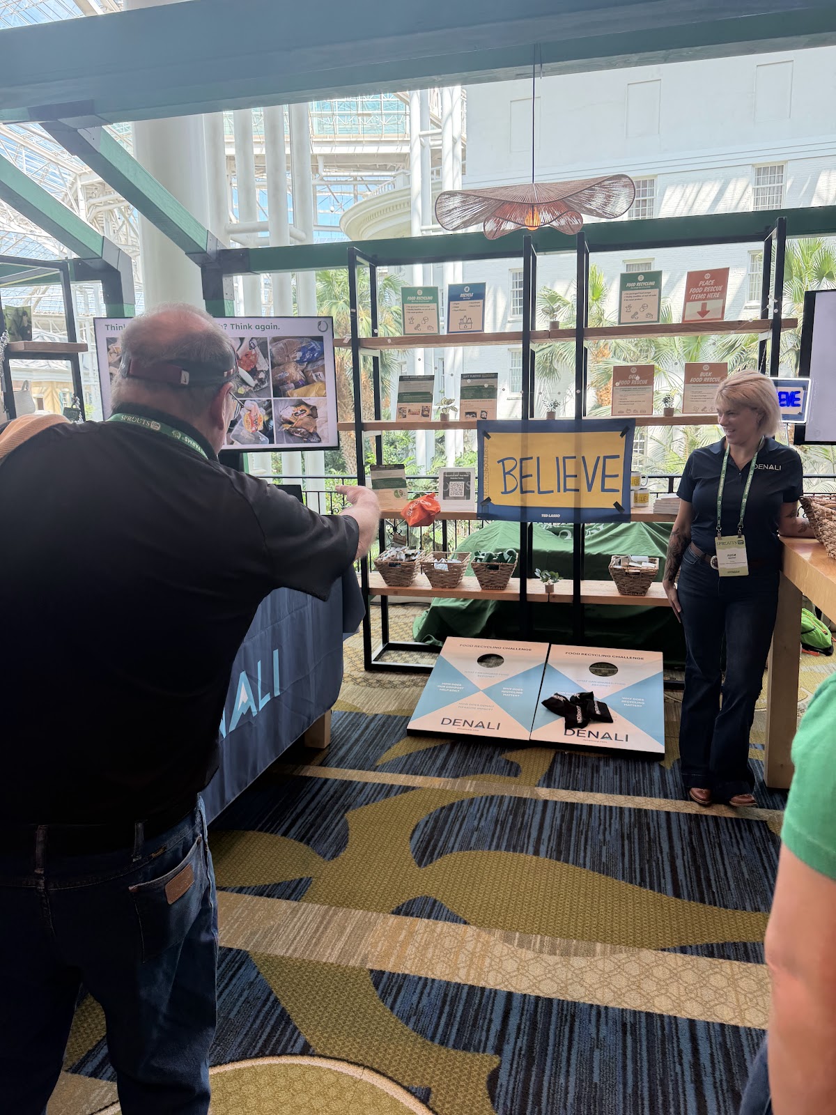 Man playing cornhole at the Denali booth at SproutsCon 2026.