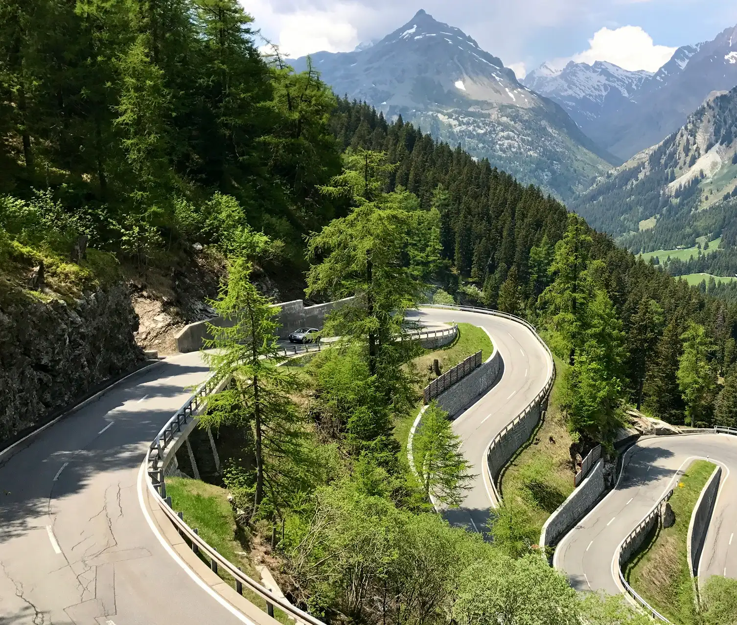 Gyönyörű, zöld erdővel borított hegyvidék egy szerpentin úttal a fókuszban.