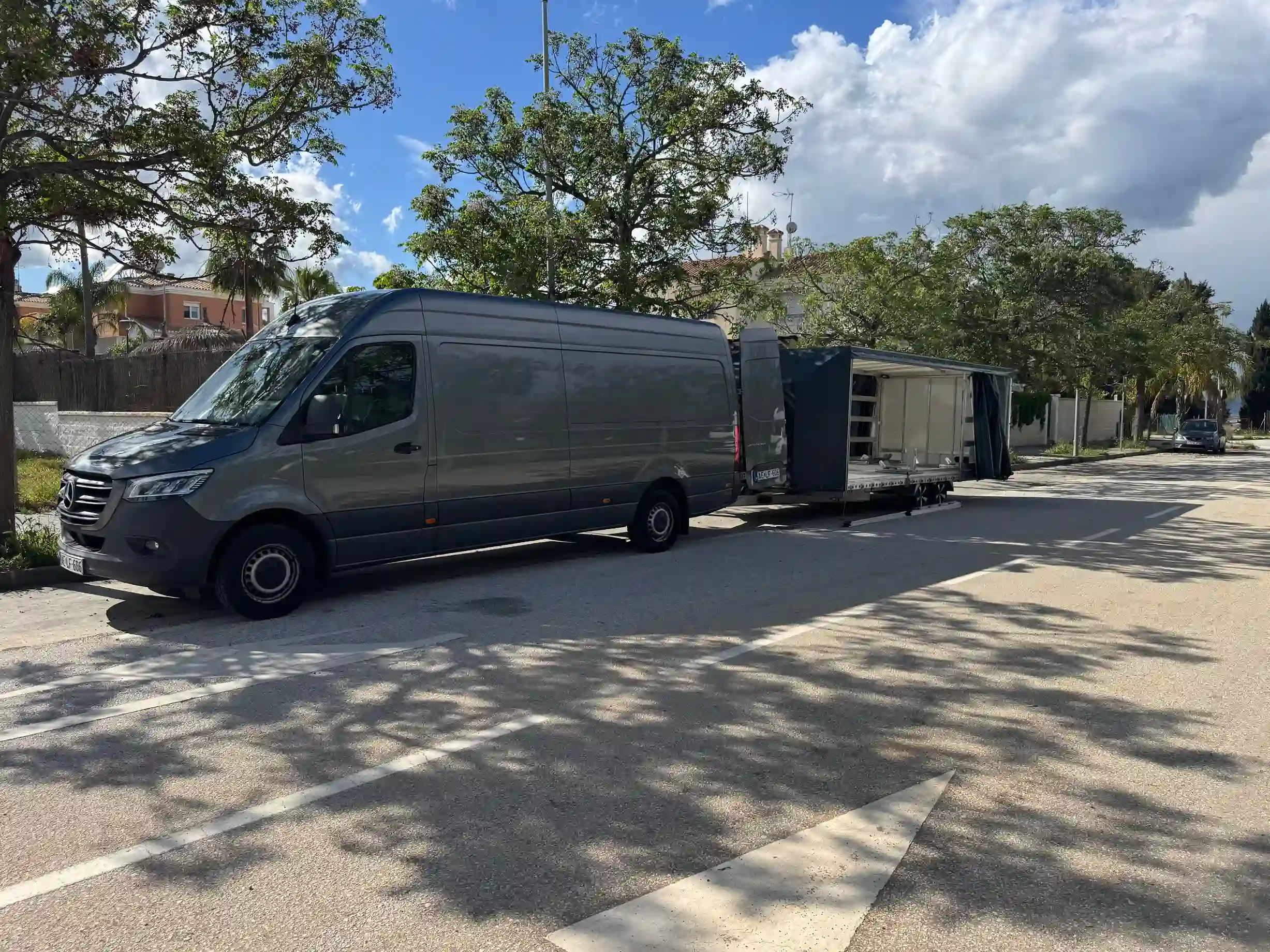 Grey van and trailer parked on the street.