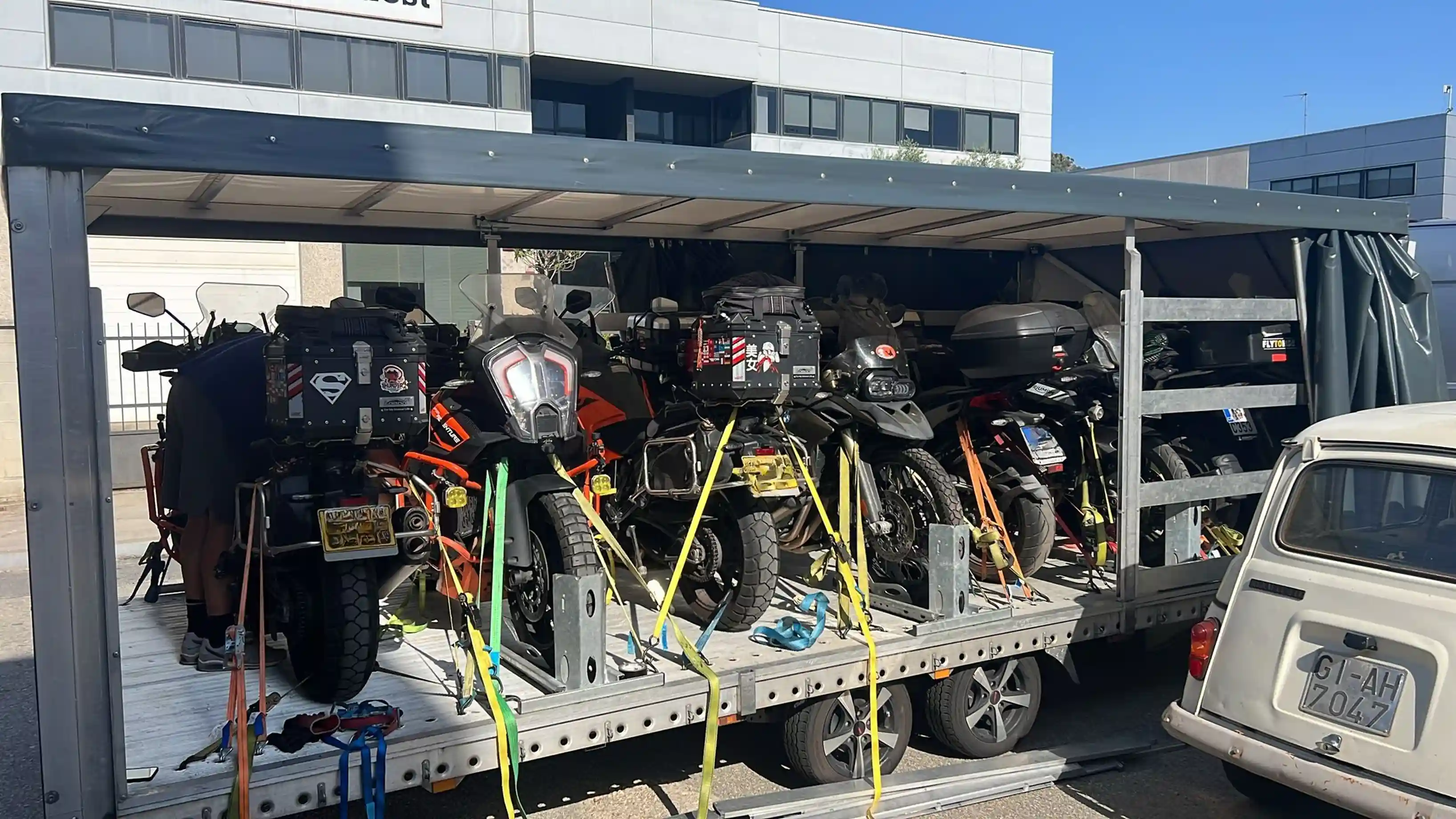 Seven motorcycles secured in an enclosed trailer, ready for departure.
