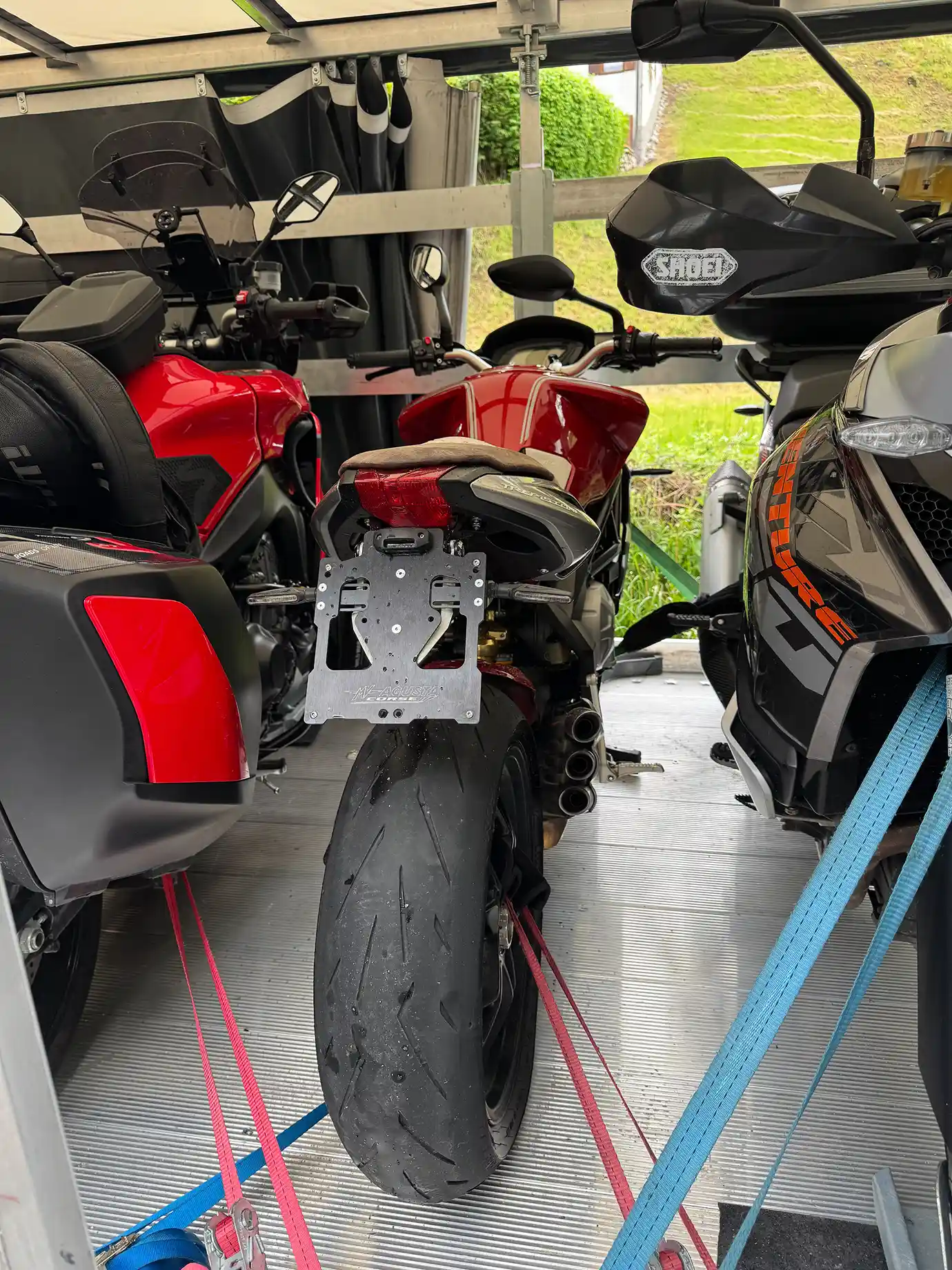 Three motorcycles secured in the trailer, ready for departure.