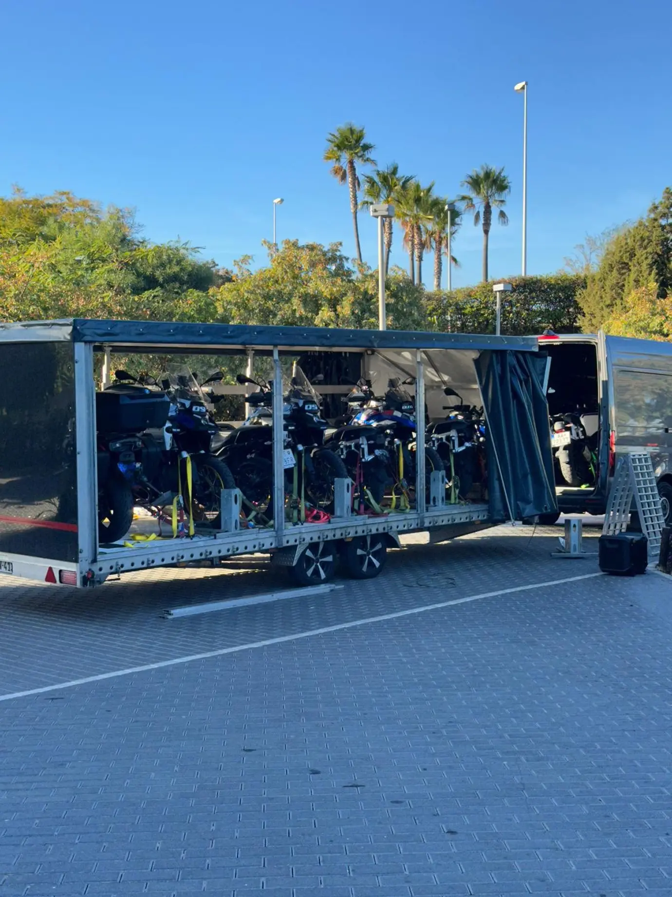 Eight motorcycles secured in an enclosed trailer, ready for departure.