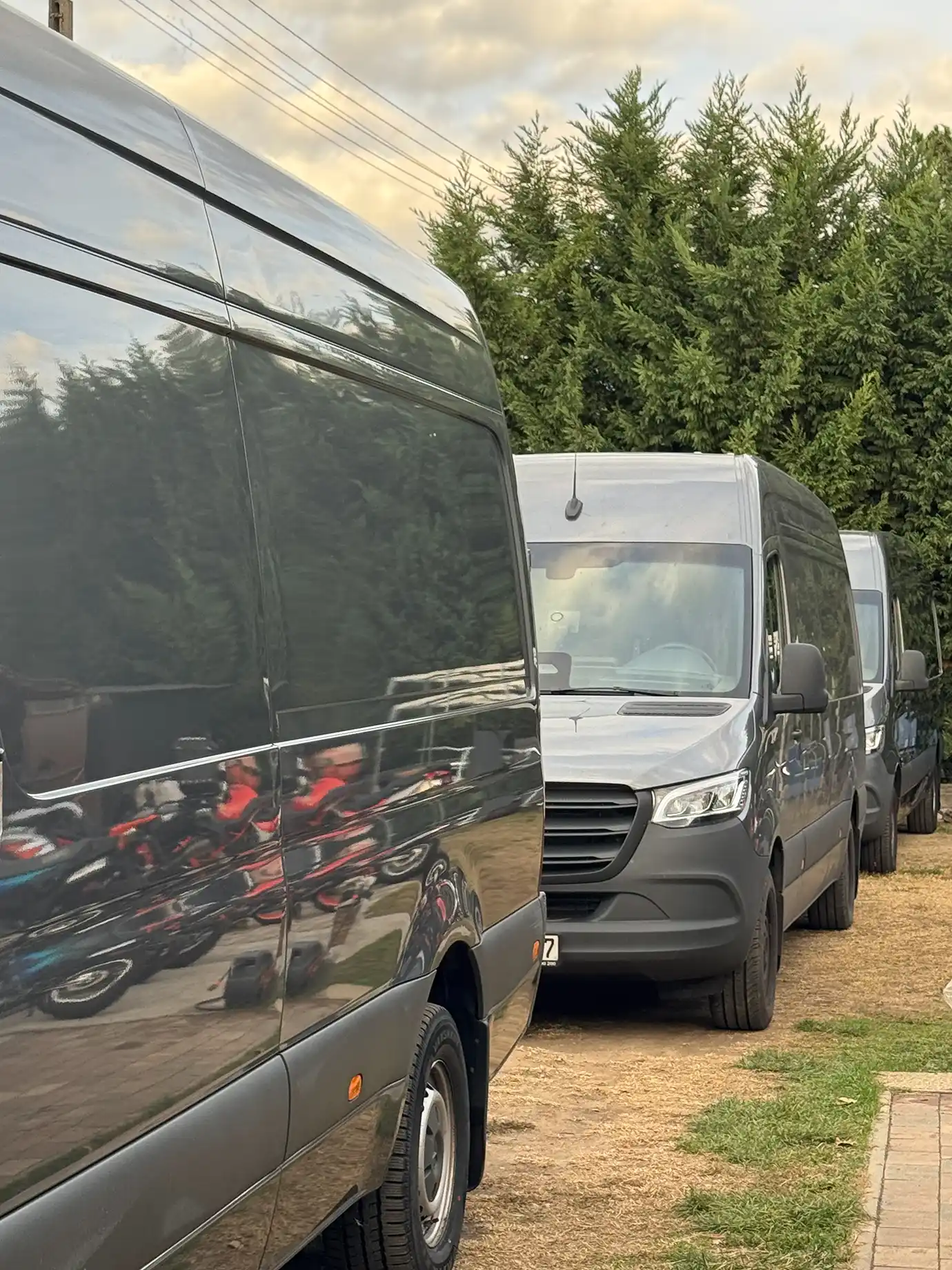 Three grey vans parked in a row.
