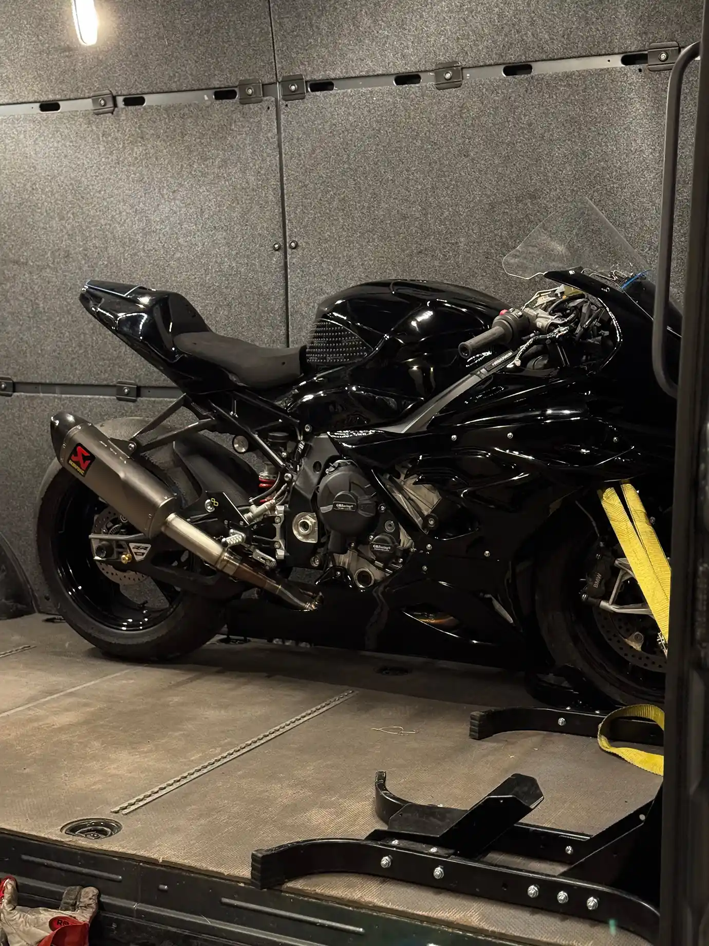 One black motorcycle securely fastened inside the van.