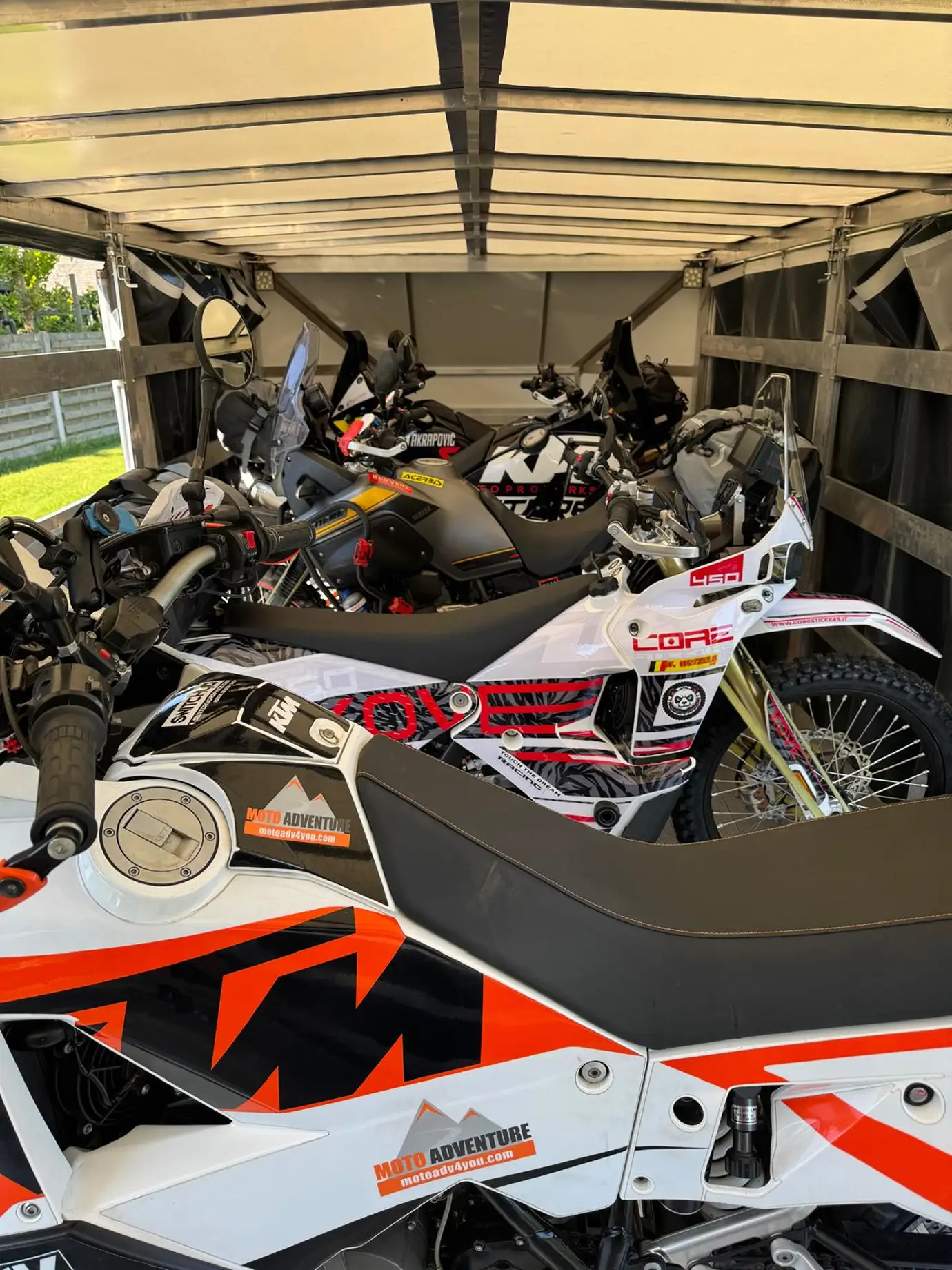 Five road motorcycles inside an enclosed trailer, ready for transport.