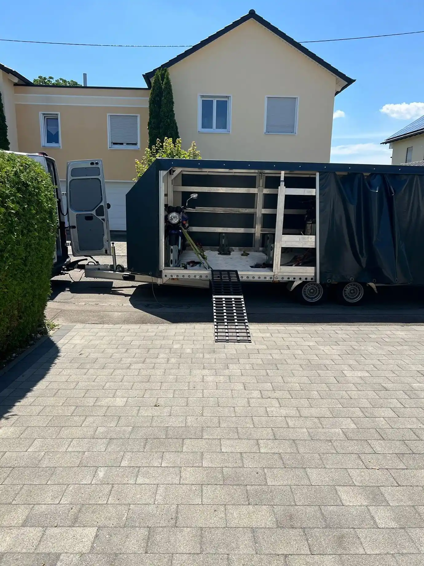 An enclosed trailer parked on the street, ready for loading motorcycles.
