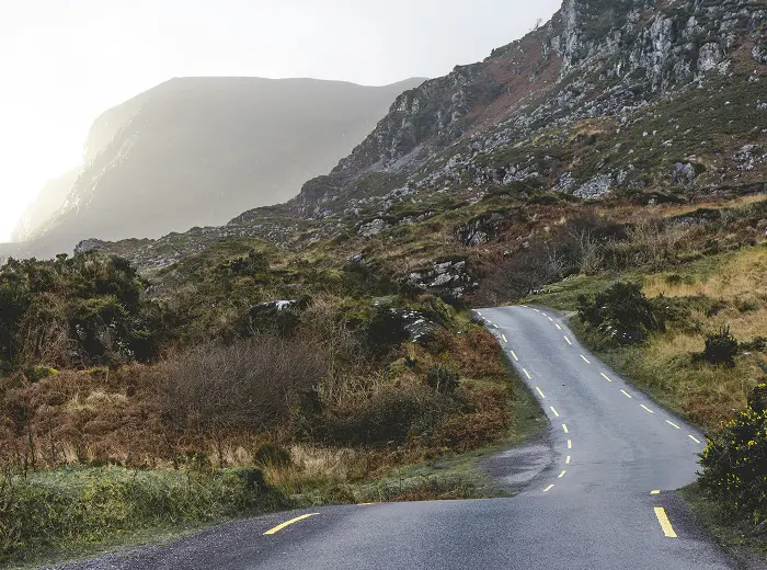 Winding asphalt road running between rocky hills