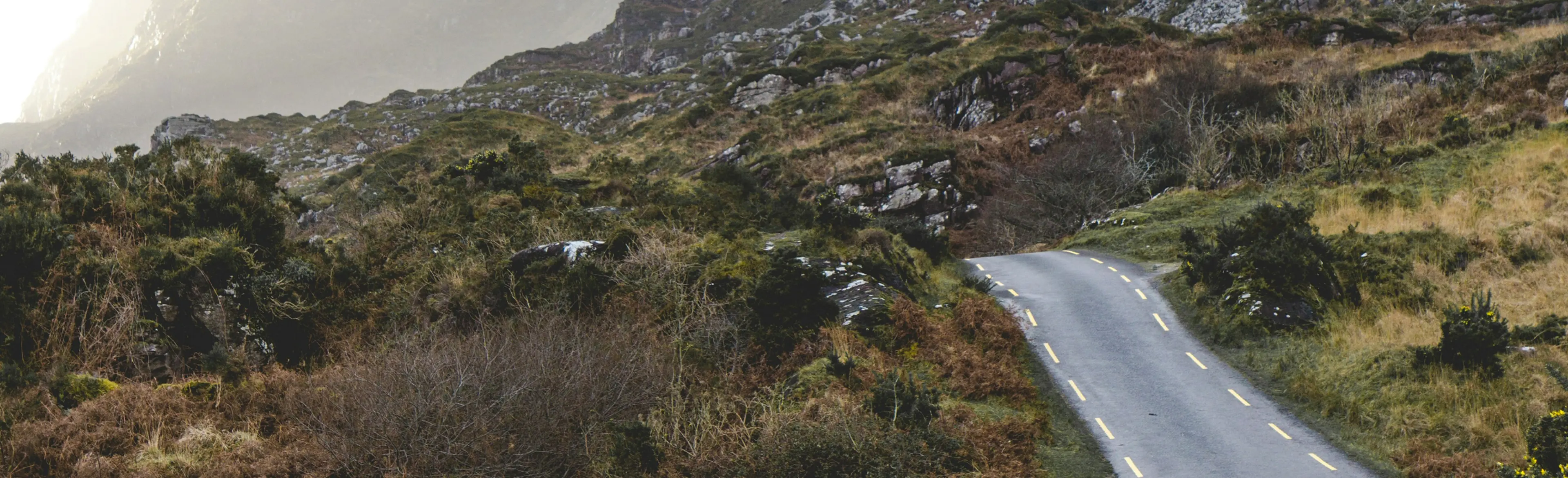 Winding asphalt road running between rocky hills