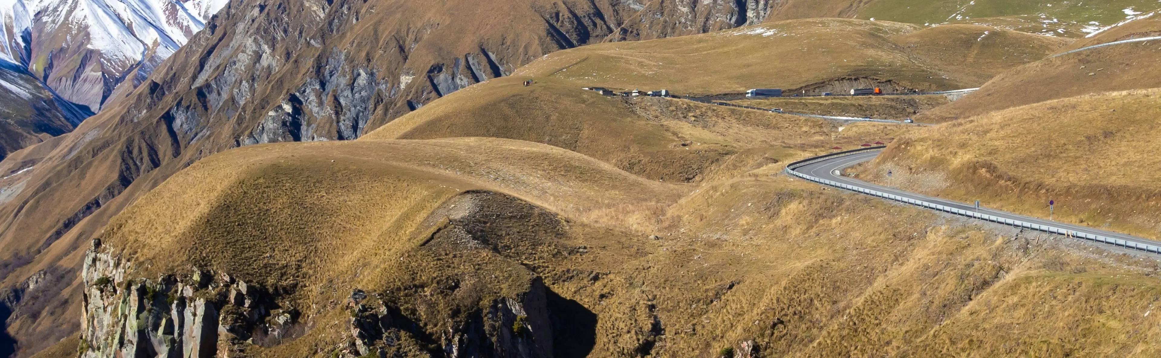 Asphalt road winding through brown hills