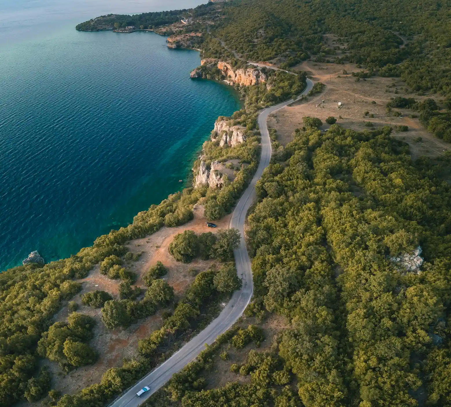Asphalt road running along the rocky beach