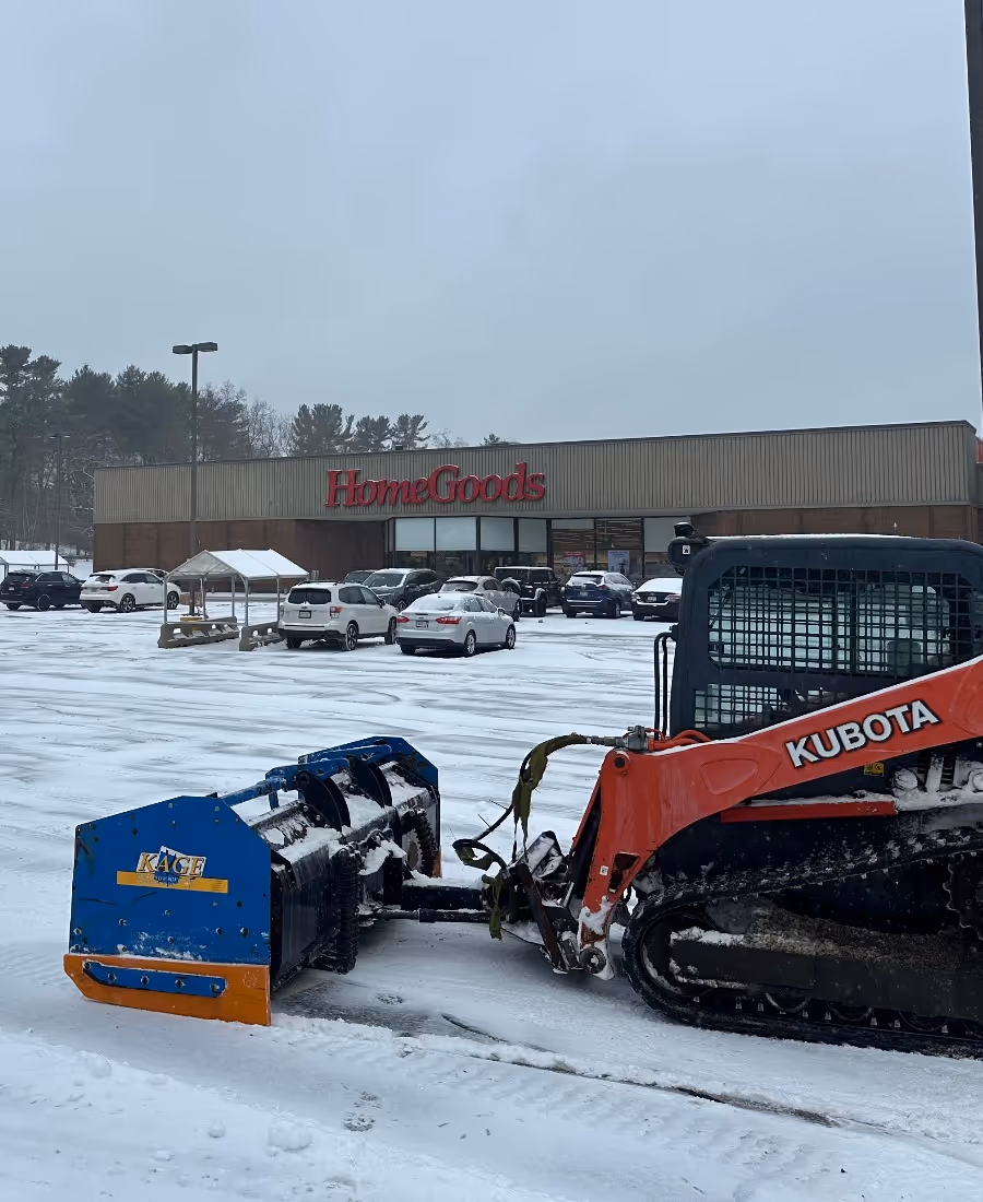 Kubota snow removal machine clearing snow in a parking lot
