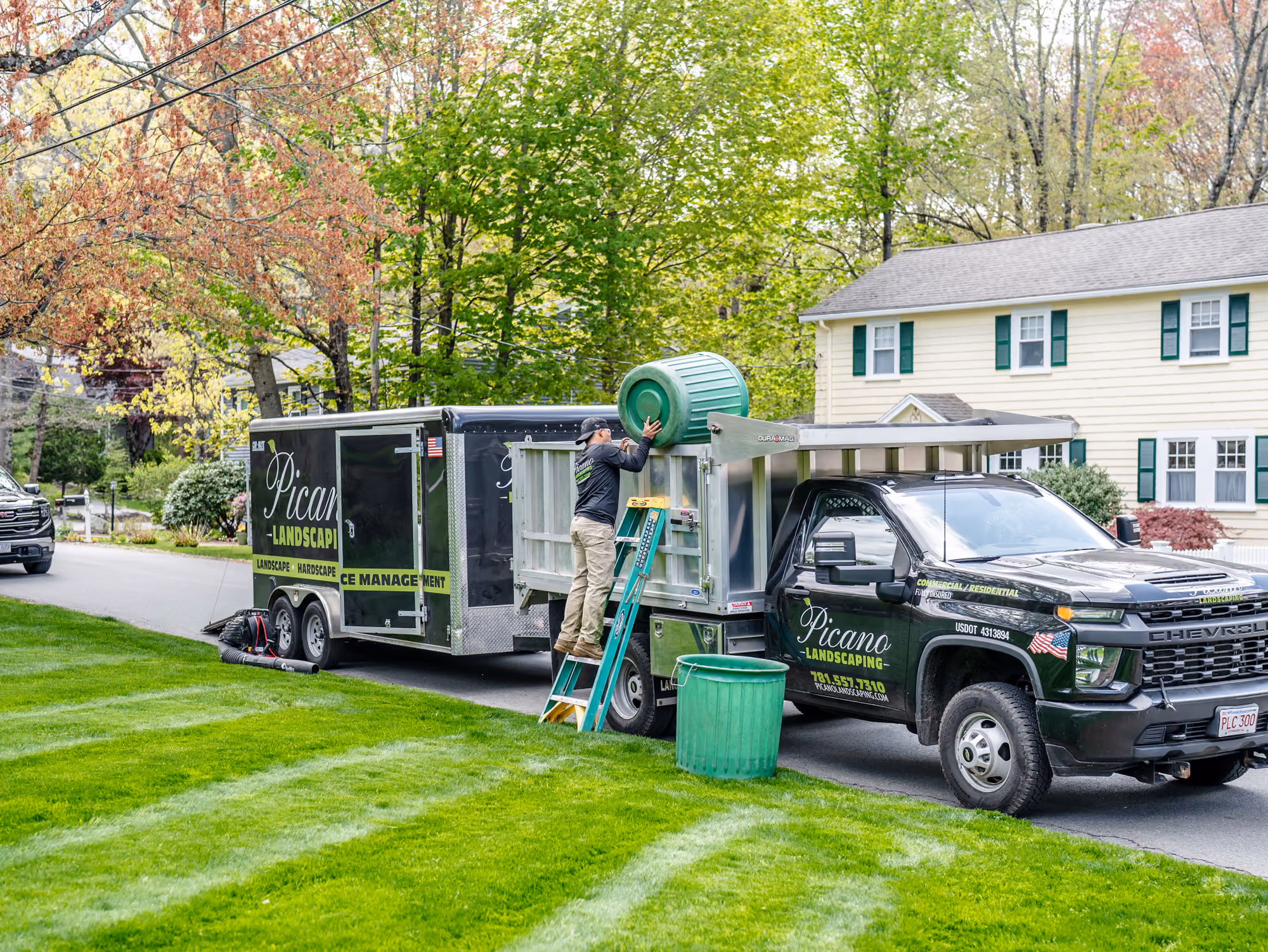 Freshly laid green sod bordered by stone edging next to a white house with a concrete walkway.