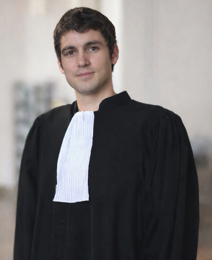 Website founder, wearing a black judicial robe with a white bib collar.