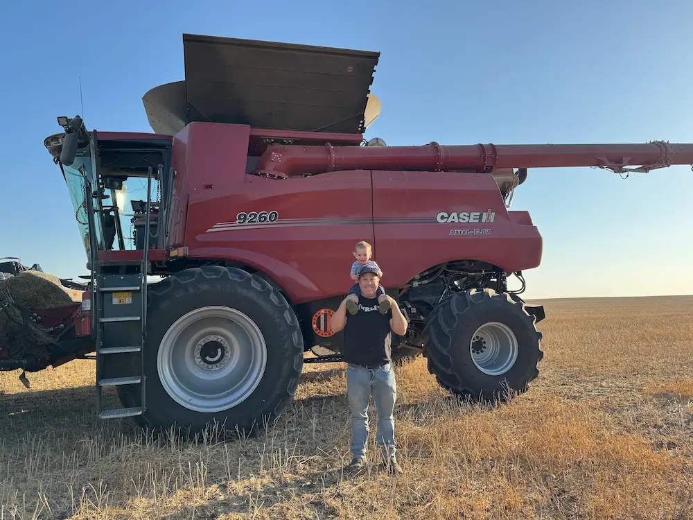 thomas winny and child standing by tractor