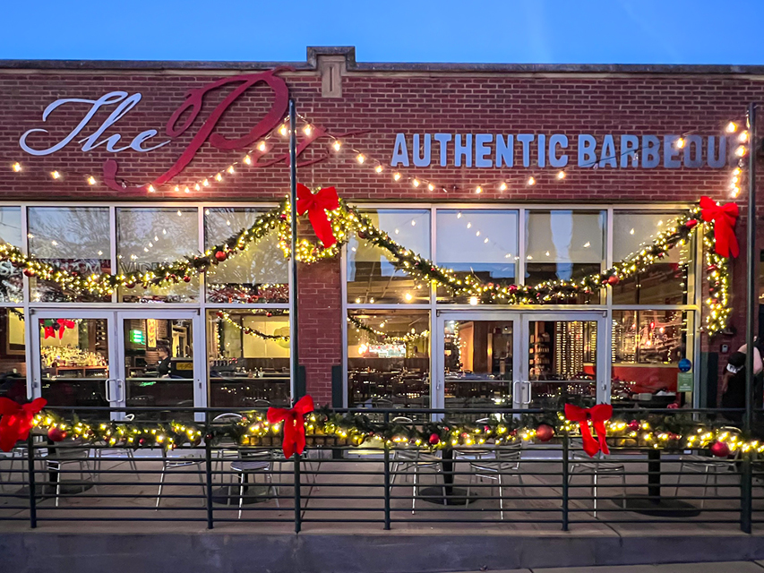 The exterior of The Pit restaurant at night decorated for Christmas