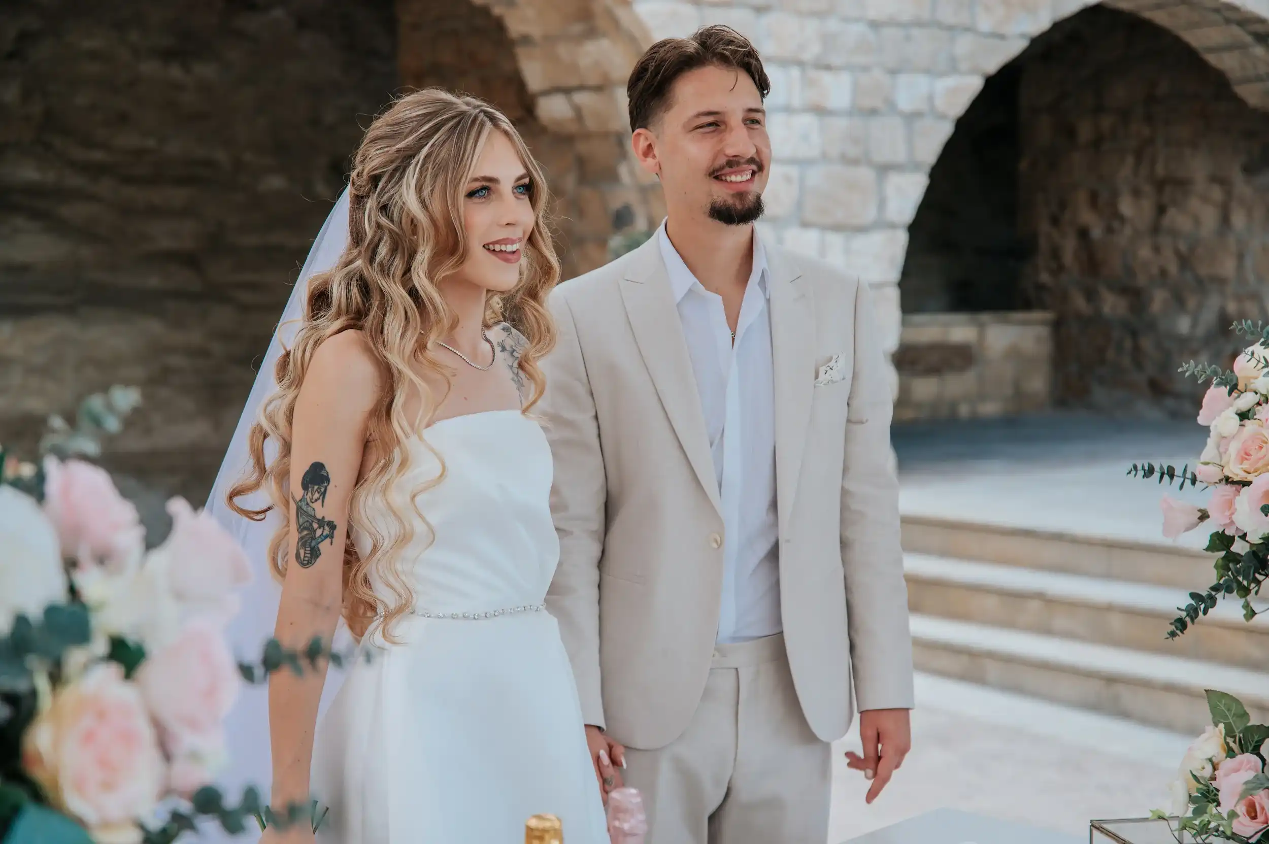 חתן וכלה עומדים יחד במהלך טקס חתונה בקפריסין בחתונת יעד אלגנטית לזוג מישראל