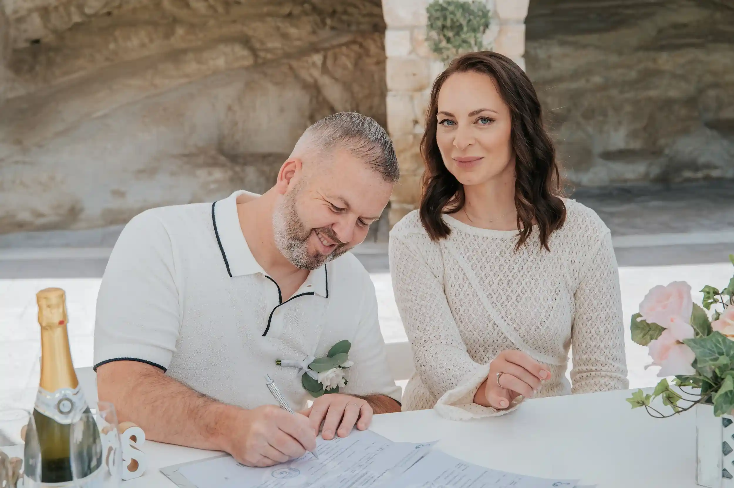 חתן וכלה חותמים על מסמכי נישואין במהלך חתונה אזרחית רשמית בקפריסין לזוג מישראל