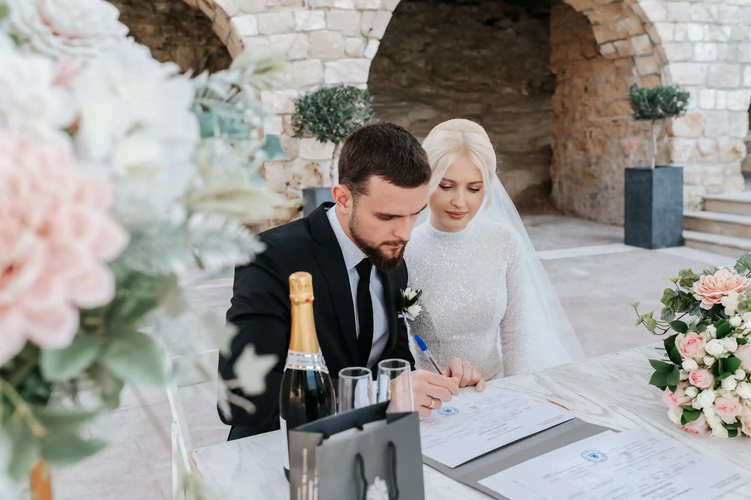 חתן וכלה חותמים על מסמכי נישואין במהלך חתונה אזרחית רשמית בקפריסין לזוג מישראל