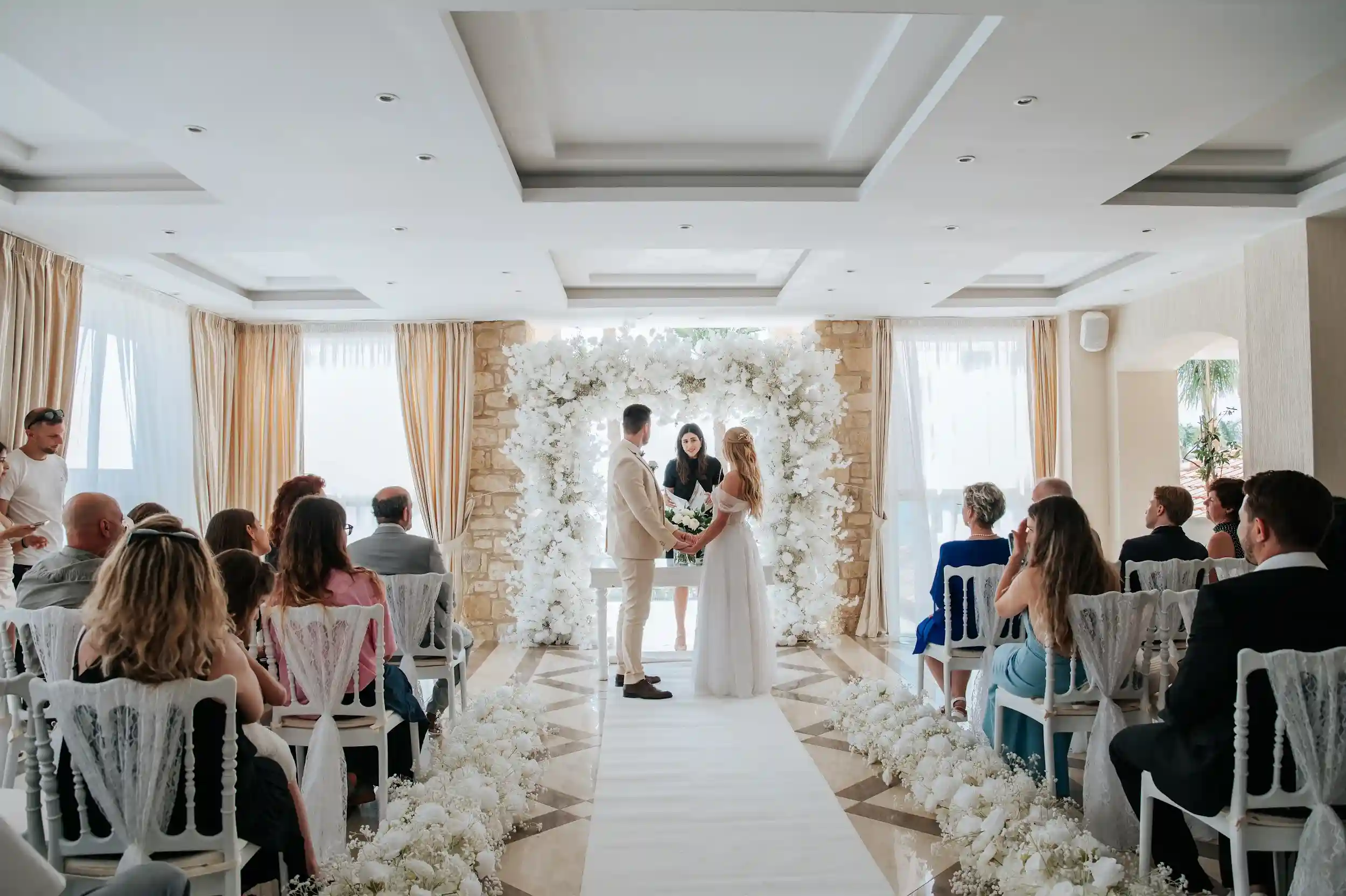 טקס חתונה רשמי באולם אלגנטי בקפריסין עם חופה מעוצבת לזוג מישראל