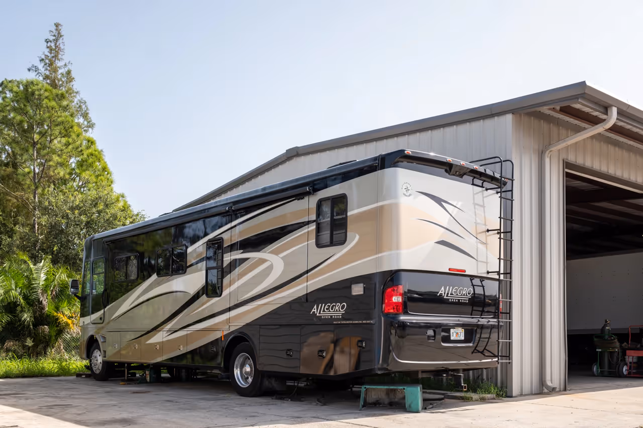 An RV car parked next to a garage in a sunny day