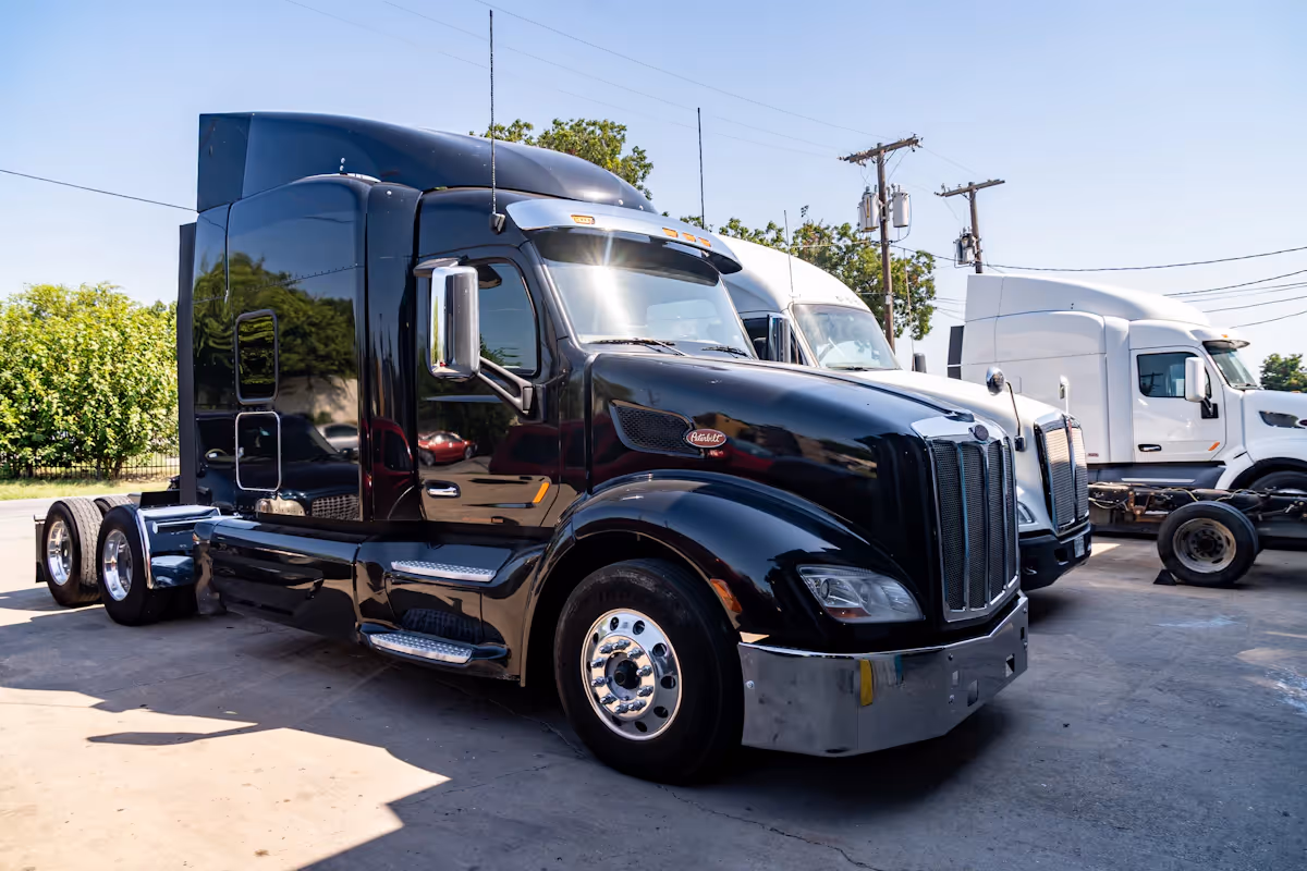 Two large semi trucks parked outside near a road