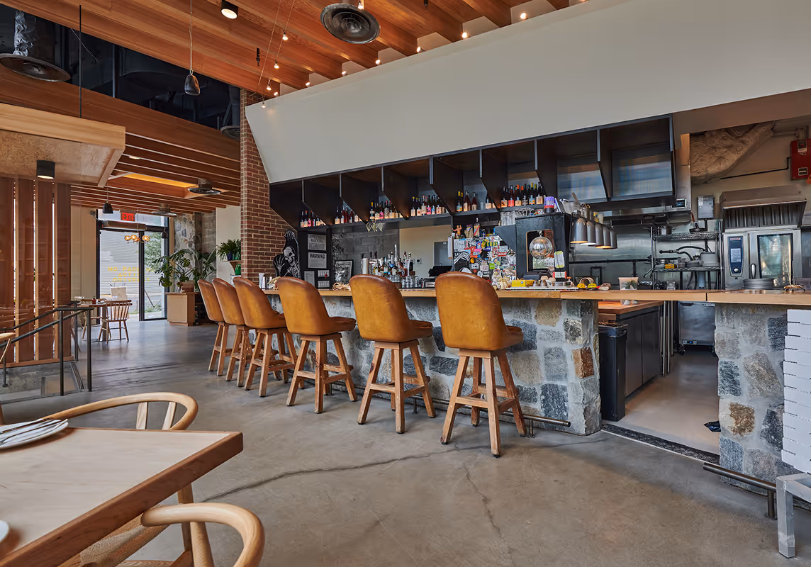 Tasting counter with wooden bar stools at Roberta’s Pizza restaurant.