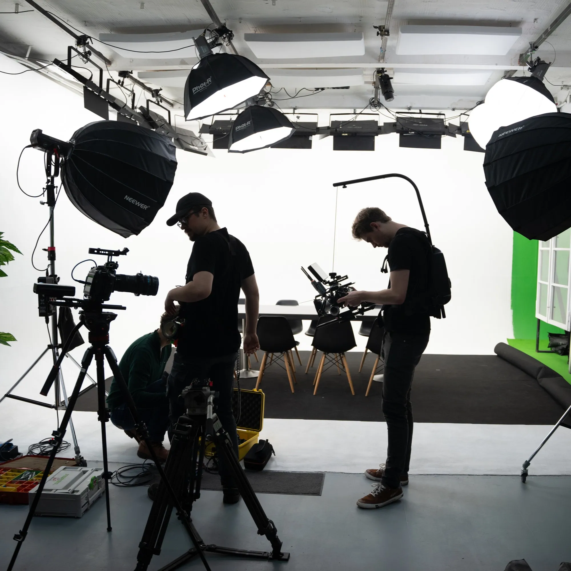 Filmteam richtet Kameras und Licht in einem Studio mit Softboxen ein