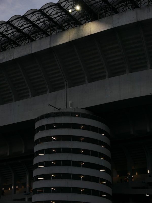 Spiral parking garage next to stadium at dusk