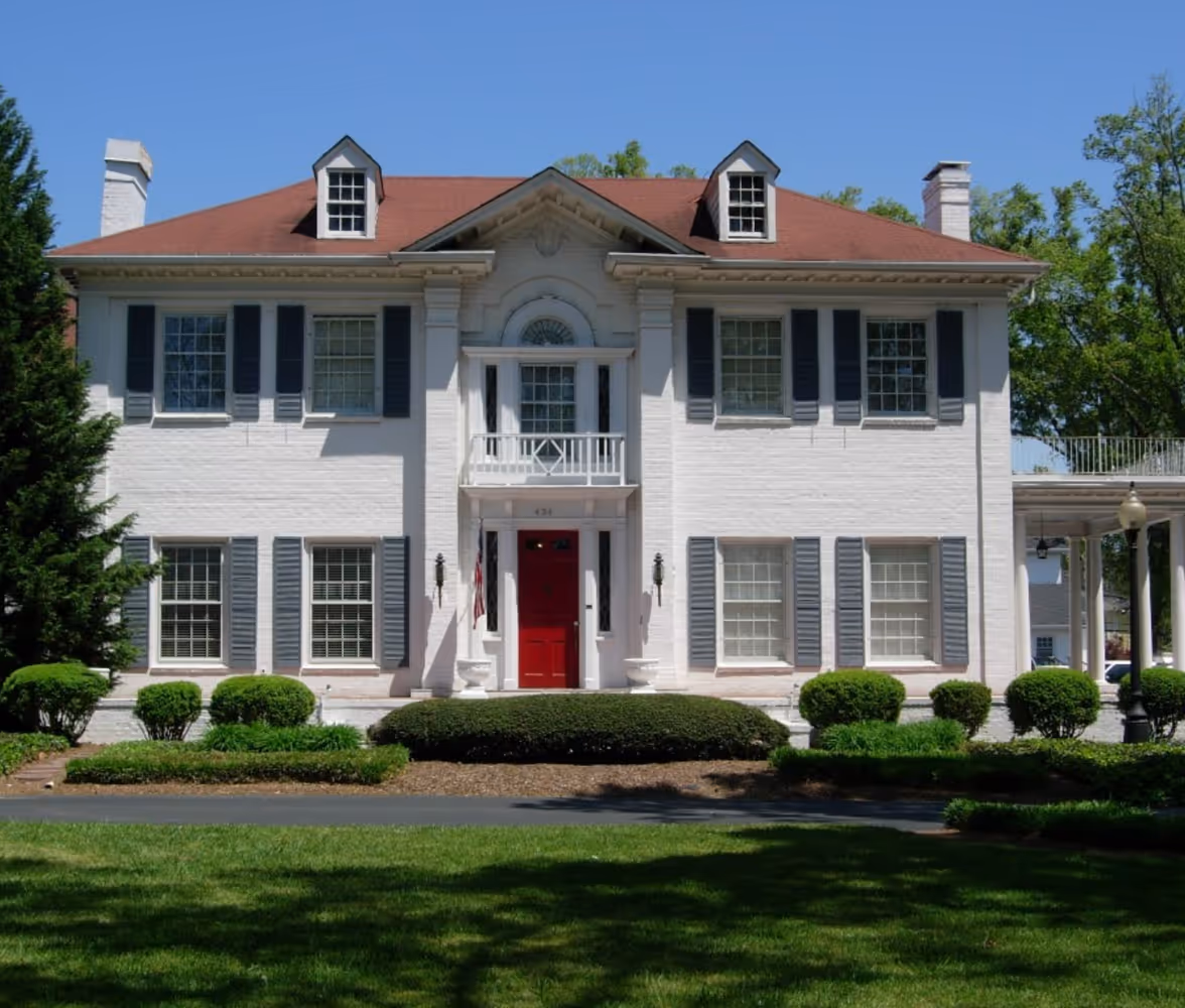 Norton real estate office in Gainesville Georgia with white brick exterior and red door.