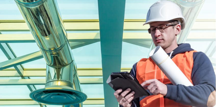 Un technicien de maintenance utilise une GMAO et une GTB