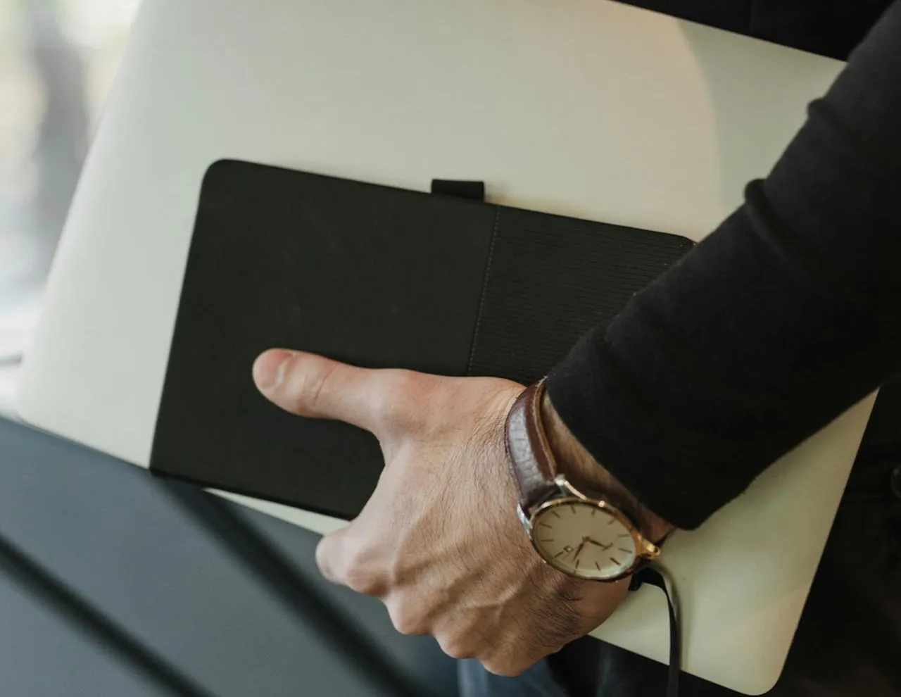 a person carrying laptop and notebook