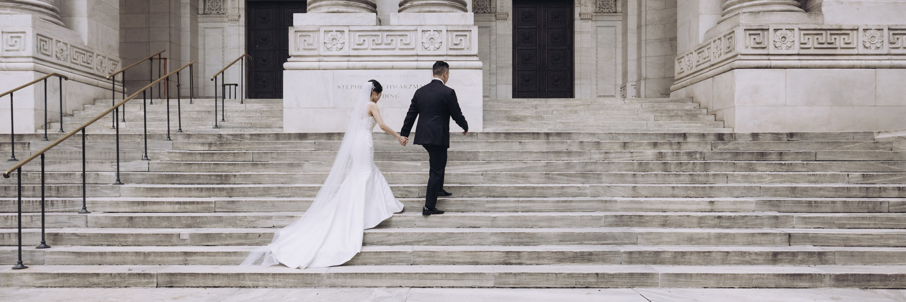 Person in a red hoodie and pink sneakers crouching and working on a laptop with a green background.