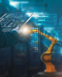 Two healthcare professionals in protective clothing using computers in a clean, sterile laboratory environment.